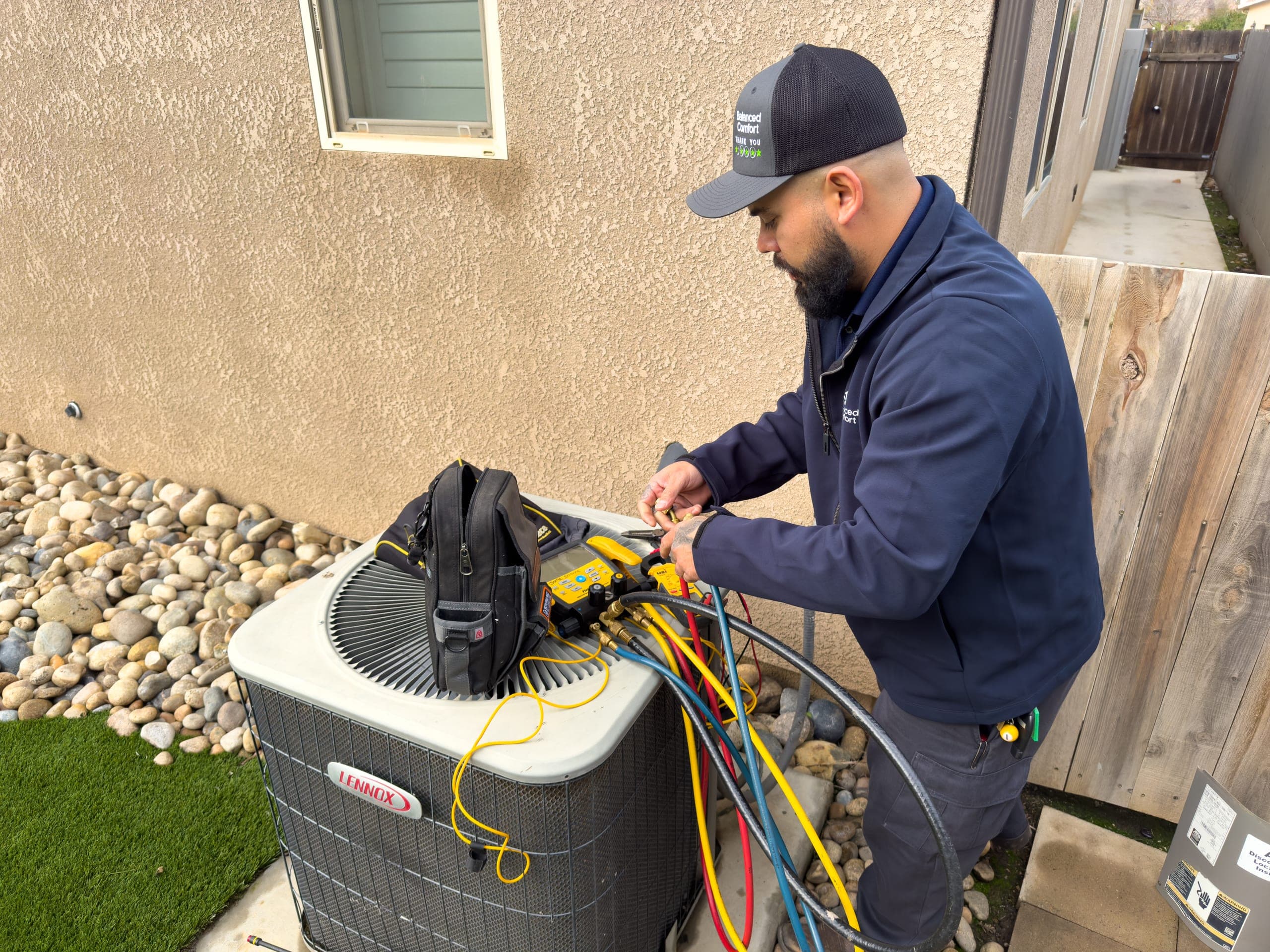 Balanced Comfort technician tuning up an air conditioner in Clovis