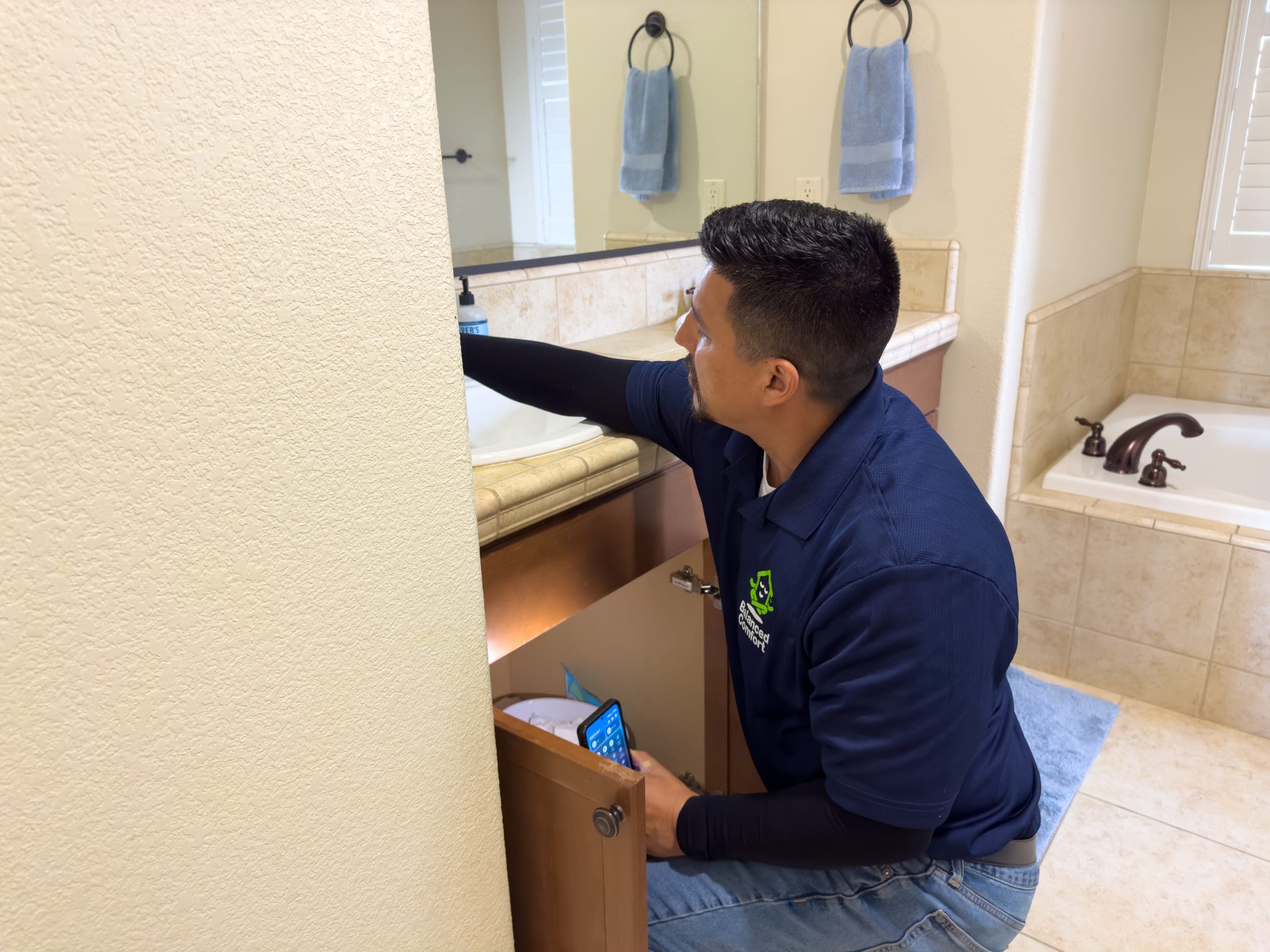 Balanced Comfort plumber repairing a bathroom sink in a Fresno home
