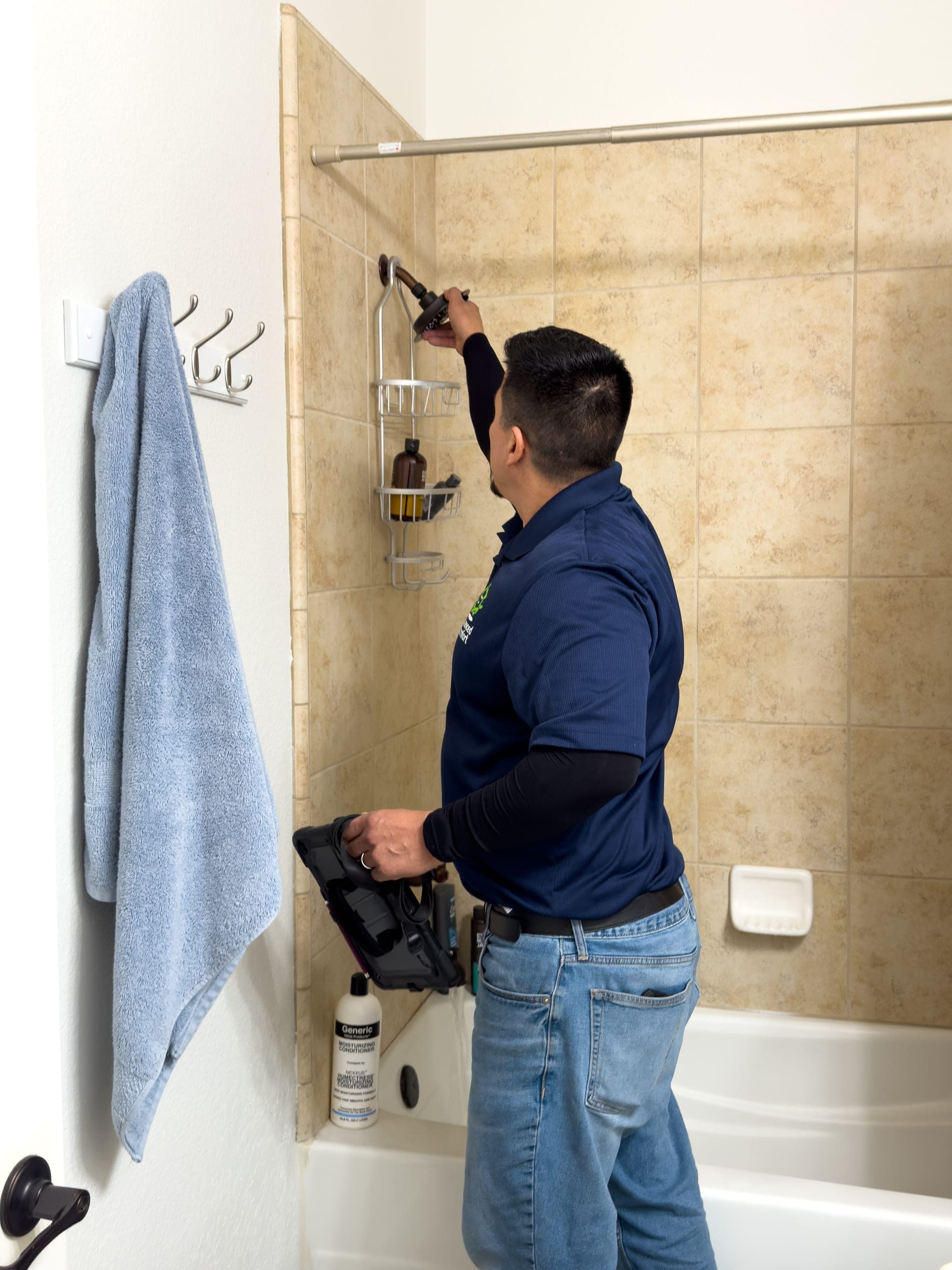 Balanced Comfort plumber repairing a shower head in a Fresno home