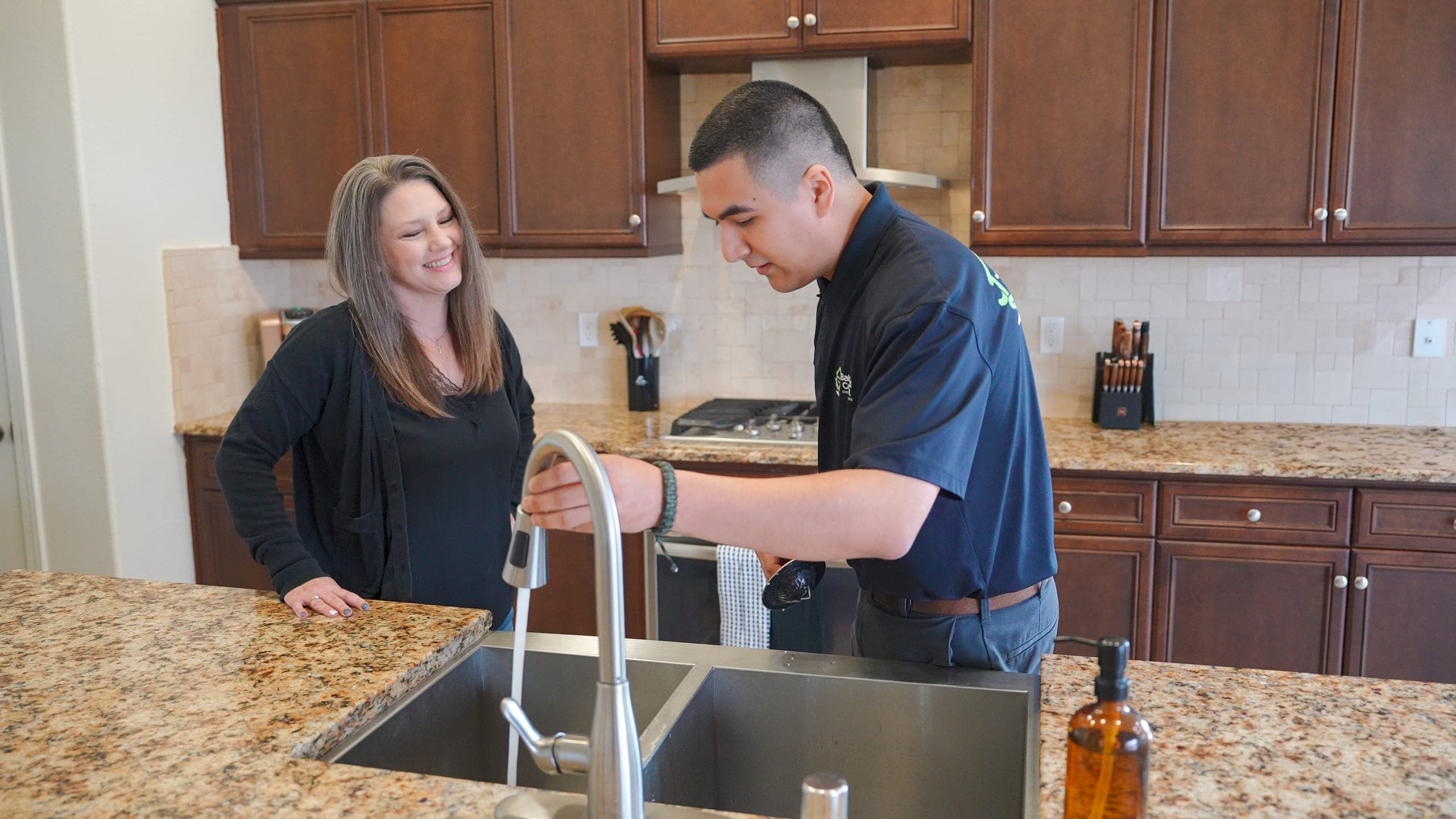 Balanced Comfort plumber working on kitchen plumbing in a Fresno home