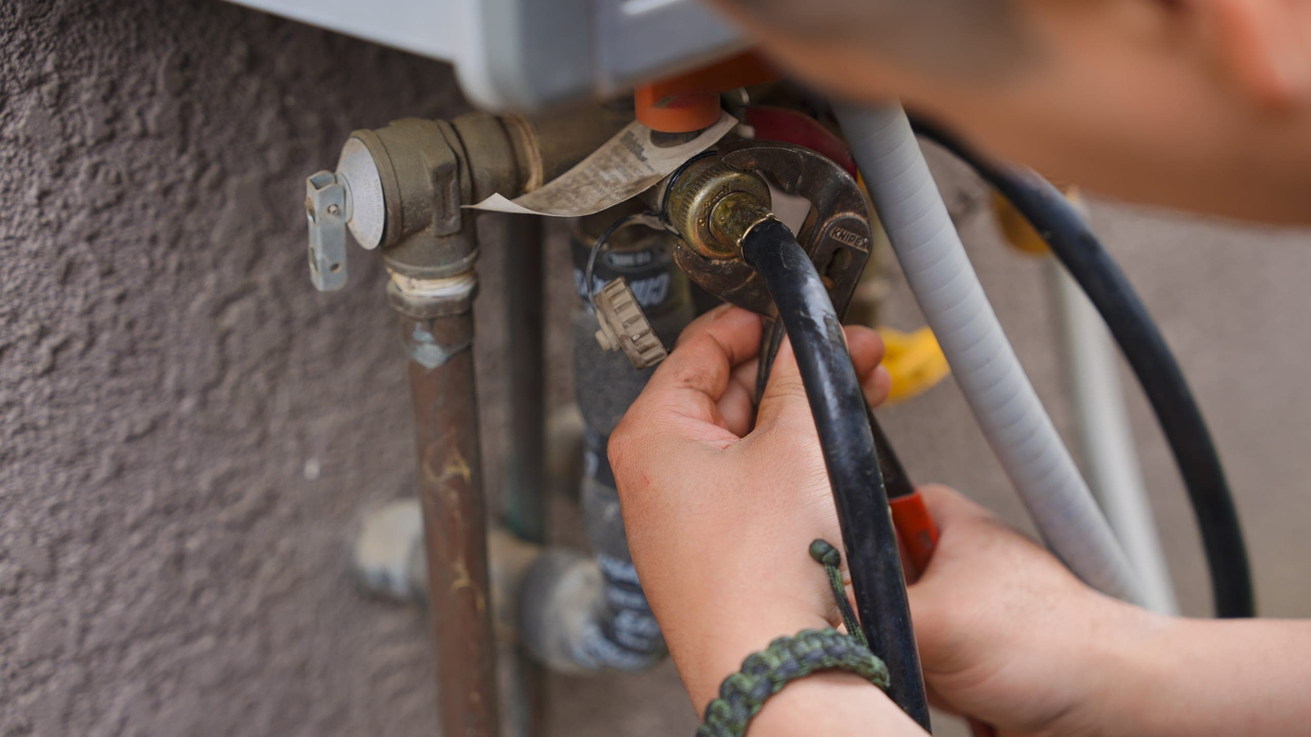 Balanced Comfort plumber flushing and inspecting a water heater
