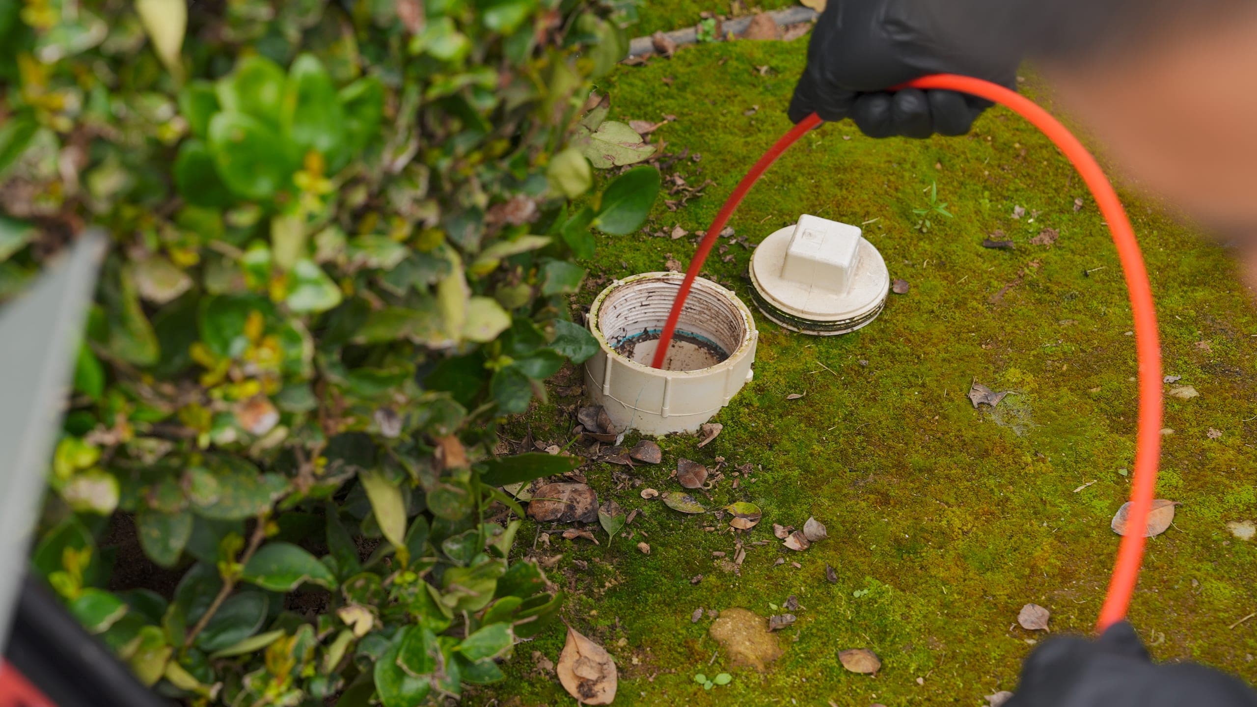 Balanced Comfort technician inspecting a drain line at an Oakhurst home