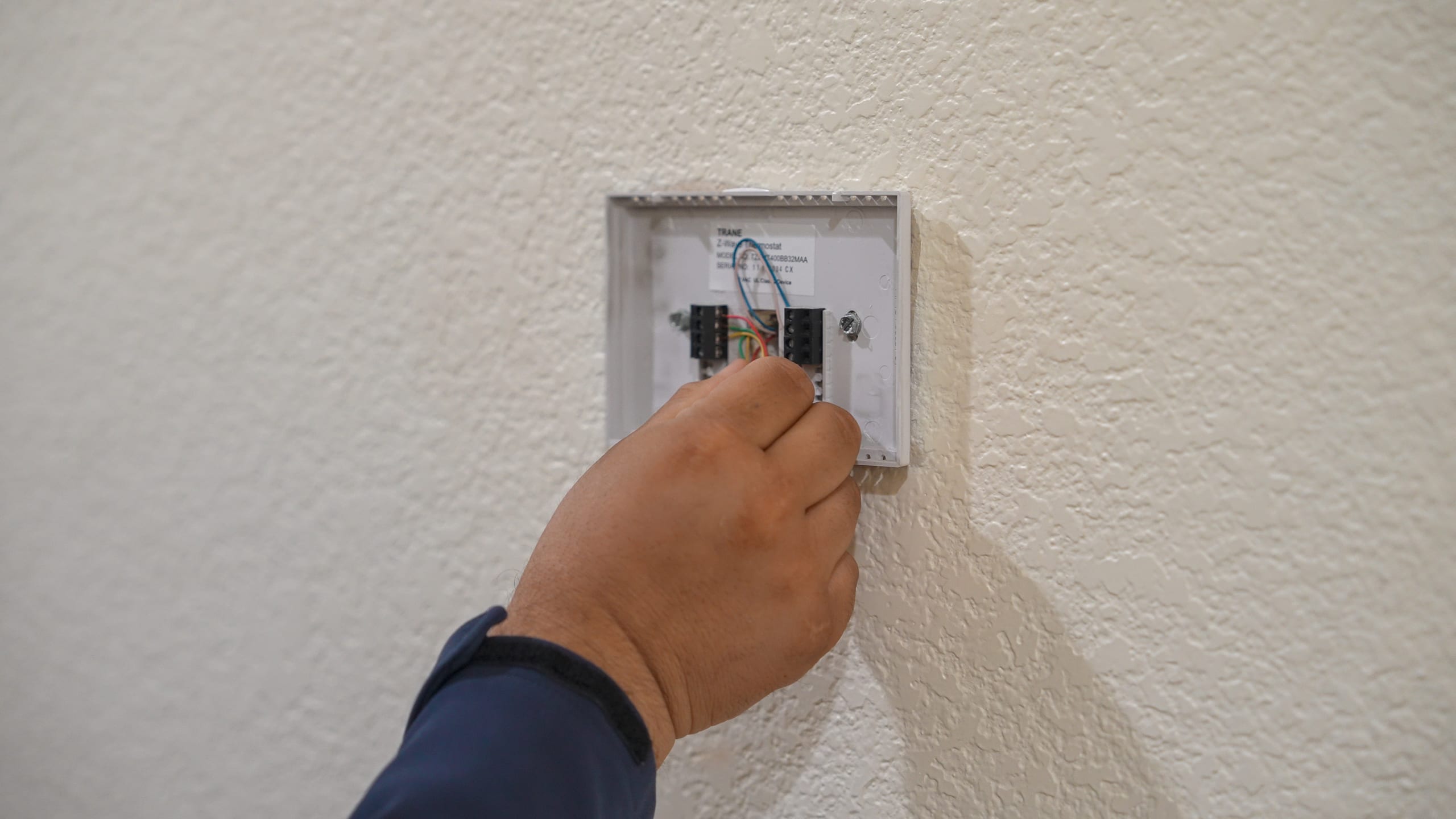 Balanced Comfort technician checking a thermostat