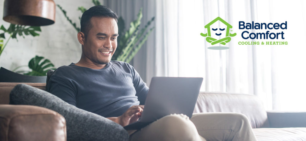 Man sitting with computer on lap Balanced comfort logo on right