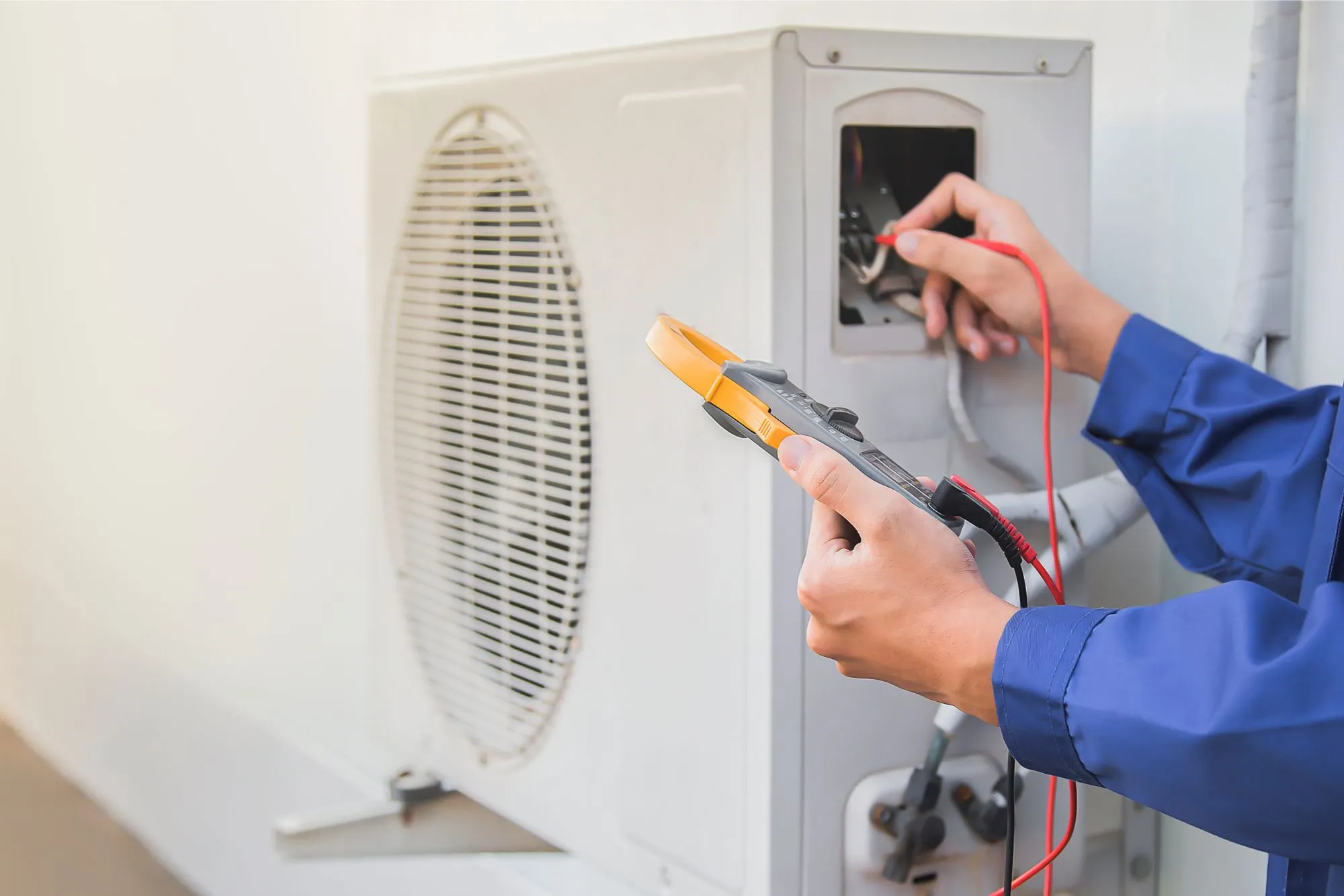 a man performs maintenance checks on an hvac unit at a home